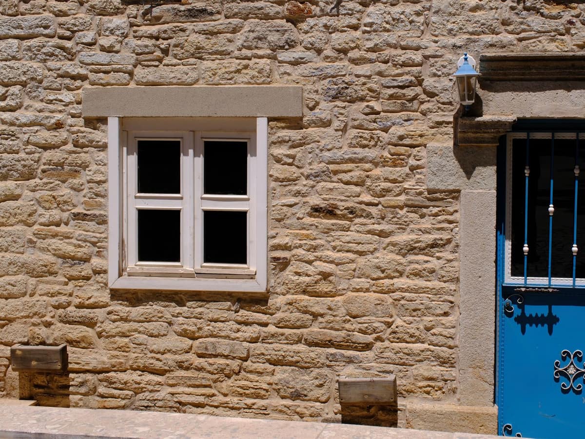 Fenêtre à linteau de pierre taillée dans un mur en pierre appareillée